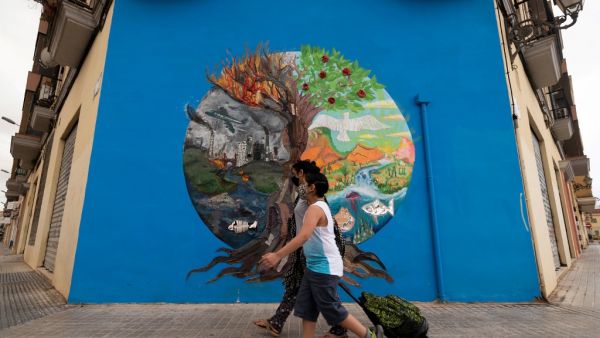 A mother escorts her child to school on the first day of classes for the new academic year in Valencia on September 7, 2020 amid the coronavirus pandemic. Spain will require all students aged six or older to wear masks and is urging them to wash their hands at least five times a day. JOSE JORDAN / AFP