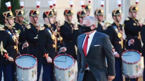Jordanian King Abdullah II, wearing a face mask, walks past guard of honour as he arrives for his meeting with the French president at the Elysee Palace in Paris on September 8, 2020. Ludovic Marin / AFP