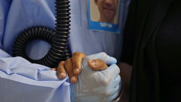 A medical worker holds a patient's hand during physiotherapy to help with oxygen circulation at the COVID-19 isolation ward of Meir Medical Center in Kfar Saba, near the Israeli coastal city of Tel Aviv, on September 9, 2020. GIL COHEN-MAGEN / AFP