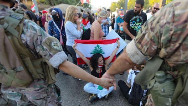 Lebanese protesters face members of the security forces during a demonstration against the lack of progress in a probe by authorities into a monster blast that ravaged swathes of the capital 40 days ago, near the presidential palace in Baabda, east of the capital Beirut, on September 12, 2020. ANWAR AMRO / AFP