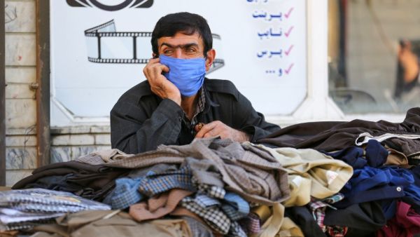 An Iranian Kurdish vendor speaks on the phone as he waits for customers in the town of Sardasht in Iran's West Azerbaijan Province on September 14, 2020. ATTA KENARE / AFP