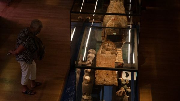 Visitors looks at a sarcophagus with a mummy inside during the exhibition "Pharaon, Osiris and mummy" at the museum Granet in Aix-en-Provence, southeastern France, on September 18, 2020. The exhibition will take place from September 19 until February 14 2021. Christophe SIMON / AFP