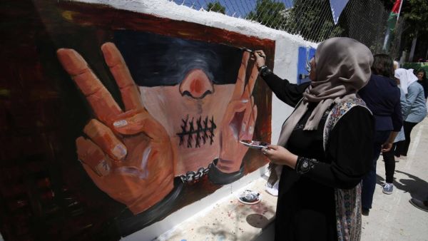Palestinian women paint murals as they mark Palestinian Prisoner Day in the West Bank city of Ramallah on 17 April 2016 (AFP)