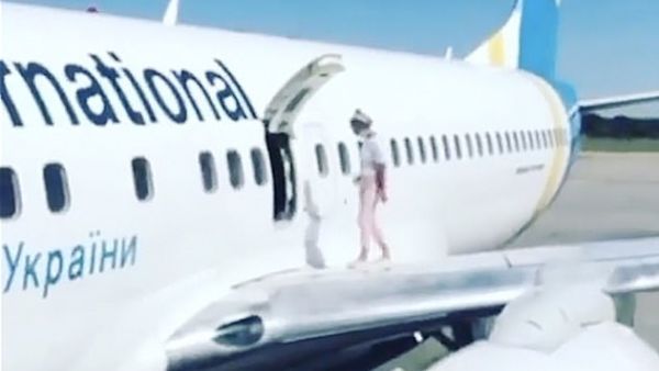 A woman climbed on to the wing of a plane after landing in Kyiv on a flight from Antalya, bizarre video footage shows (Instagram)