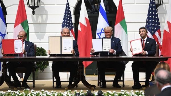 The four leaders hold up the signed copies of the Abraham Accords - they signed one in English, one in Hebrew and two in Arabic (AFP)
