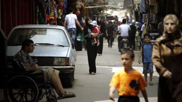 Palestinians walk along a shopping street in the Beddawi refugee camp in Tripoli in August 2010 (AFP)