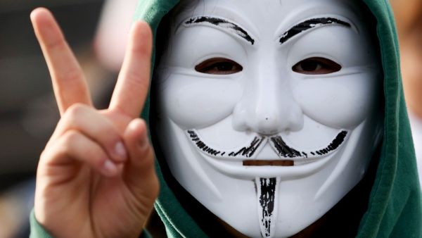 A protester wearing a mask flashes V-sign during a rally demanding to free jailed activists of the opposition in Minsk, on October 4, 2020. Belarusian police on October 4, 2020 used water cannon to disperse a rally in Minsk as tens of thousands of demonstrators took to the streets in the latest weekend protest against strongman Alexander Lukashenko's disputed re-election. STRINGER / AFP