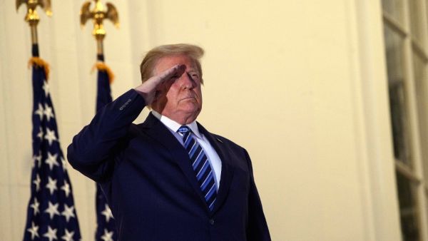  In this file photo US President Donald Trump salutes from the Truman Balcony upon his return to the White House from Walter Reed Medical Center, where he underwent treatment for Covid-19, in Washington, DC, on October 5, 2020. President Donald Trump doubled down on October 6, 2020 on the macho image his fans adore after declaring himself cured of Covid-19 and scoffing at disastrous opinion polls only four weeks before election day against Democrat Joe Biden."FEELING GREAT!" he tweeted, also insisting that 