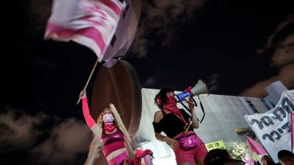 An Israeli protester addresses the crowd with a megaphone during a demonstration against Prime Minister Benjamin Netanyahu in the coastal city of Tel Aviv, on October 10, 2020. EMMANUEL DUNAND / AFP