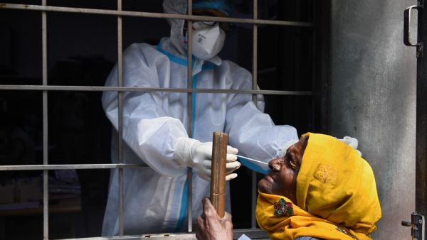 A health worker collects a swab sample from a resident to test for the Covid-19 coronavirus at a testing centre in New Delhi on October 19, 2020. Sajjad HUSSAIN / AFP