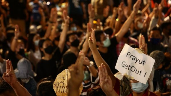 A sign directed at Thailand's Prime Minister Prayut Chan-O-Cha is held up by a pro-democracy protester during an anti-government rally on the ouskirts of Bangkok on October 19, 2020. Jack TAYLOR / AFP