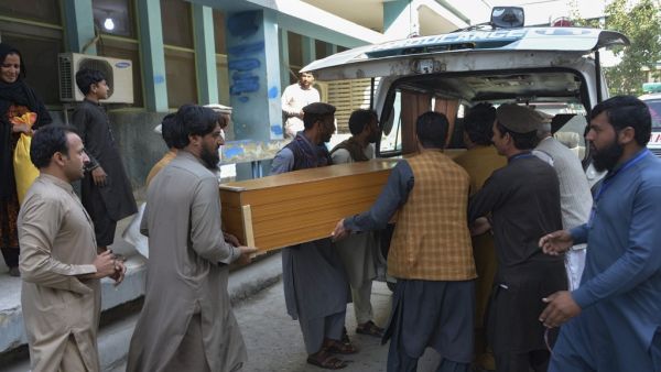Relatives carry the coffin of a victim, who was killed in a stampede, outside a mortuary in Jalalabad on October 21, 2020. At least 11 women were killed on October 21 in a stampede at a stadium in eastern Afghanistan where thousands had gathered to apply for visas at a nearby Pakistan consulate, officials said. NOORULLAH SHIRZADA / AFP