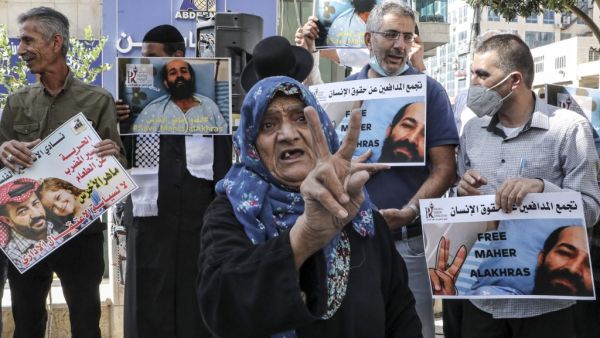 Palestinian protesters hold up signs in solidarity with hunger-striking Palestinian detainee held by Israel Maher al-Akhras and other Palestinians in Israeli prisons during a demonstration in the centre of the flashpoint West Bank city of Hebron on October 21, 2020. (AFP)