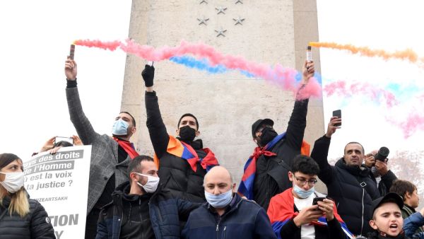 Men demonstrate with fumigenes during a rally called by the Coordination Council of Armenian Organizations of France (CCAF) to protest against conflict in Nagorno-Karabakh, in Paris, on October 25, 2020. Alain JOCARD / AFP