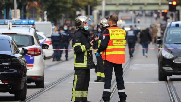 French policemen and firefighters stand guard a street after a knife attack in Nice on October 29, 2020. A man wielding a knife outside a church in the southern French city of Nice slit the throat of one person, leaving another dead and injured several others in an attack on Thursday morning, officials said. (AFP)
