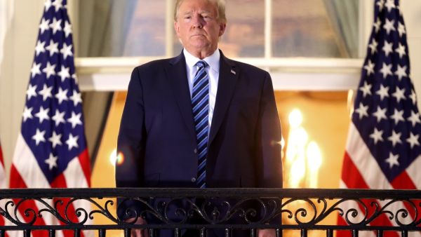 U.S. President Donald Trump stands on the Truman Balcony after returning to the White House from Walter Reed National Military Medical Center on October 05, 2020 in Washington, DC. Trump spent three days hospitalized for coronavirus. Win McNamee/Getty Images/AFP