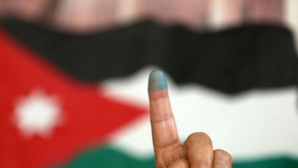 A Jordanian woman shows her ink-stained finger after voting Tuesday morning in the parliamentary elections. (AFP/Khalil Mazraawi)