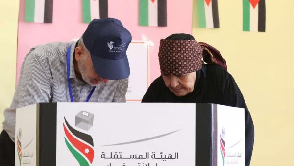 A Jordanian woman is assisted by a member of the electoral commission as she casts her ballot in the parliamentary elections at a polling station in the capital Amman on September 20, 2016. (AFP)
