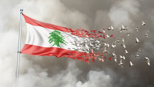 Lebanon flag on a pole turn to birds while waving against a background of smoke. Blast scene on the Lebanese capital of Beirut  (Shutterstock) 