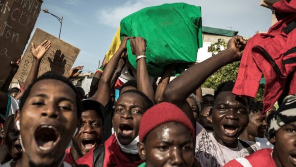 Demonstrators carry a coffin as they take part in a march in the streets of Dakar, on October 30, 2020, called by the Guinean diaspora to protest against the results of the presidential elections in Guinea. Protests against Guinea's President Alpha Conde will resume next week, the political opposition said on October 30, 2020, after 10 losing candidates in the country's election rejected the official outcome. JOHN WESSELS / AFP