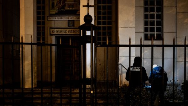 Police officers examine the entrance of the Orthodox Church where an attacker armed with a sawn-off shotgun wounded an Orthodox priest in a shooting before fleeing, on October 31, 2020 in Lyon, said a police source. (AFP/File)