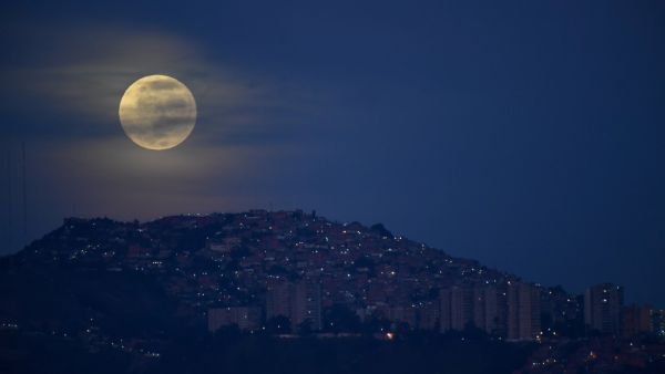 The "blue moon", the second full moon of a calendar month, is seen over the Valle shantytown in Caracas, on October 31, 2020. Federico PARRA / AFP