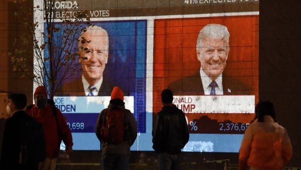 People watch a big screen displaying the live election results in Florida at Black Lives Matter plaza across from the White House on election day in Washington, DC on November 3, 2020. Olivier DOULIERY / AFP