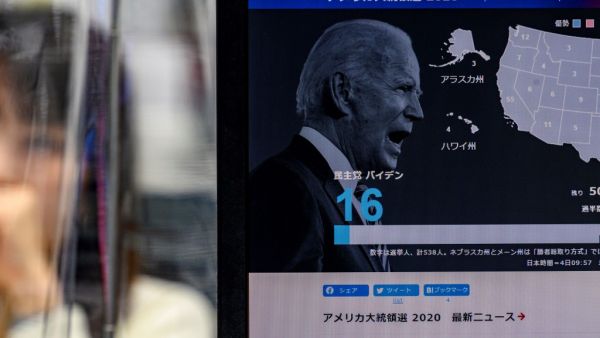 A news website shows a portrait of US presidential candidate Joe Biden at a foreign exchange trading company in Tokyo on November 4, 2020, as Asian markets react to early predictions following the US presidential election. Philip FONG / AFP