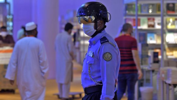 An Emirati policeman uses a smart helmet to detect people's temperature as a tool to fight the spread of the Covid-19 coronavirus among the visitors of the the Sharjah International Book Fair in Sharjah, northeast of Dubai, on November 4, 2020.   Karim SAHIB / AFP