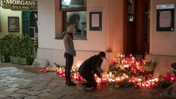 A couple light up some candles in front of a restaurant the place of the terrorist attack in Vienna, Austria on November 4, 2020. More details emerged on November 4, 2020 about the attacker who killed four on in Vienna before being shot dead by police, described as a "lost soul" of 20 already jailed once for support of the "Islamic State" (IS) group.  JOE KLAMAR / AFP