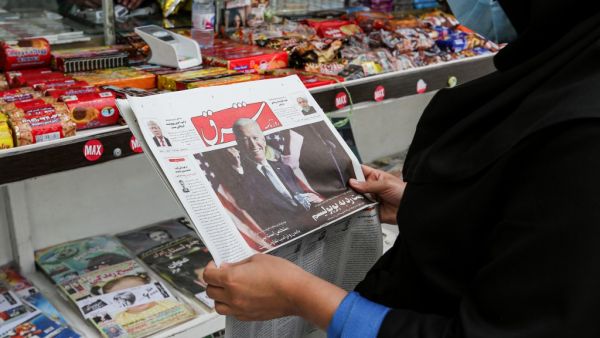 A woman browses the front page of Iranian Farsi newspaper Shargh featuring the 2020 US general election results at a news stand in Iran's capital Tehran on November 8, 2020. ATTA KENARE / AFP