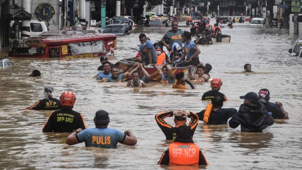 Rescuers pull a rubber boat carrying residents through a flooded street after Typhoon Vamco hit in Marikina City, suburban Manila on November 12, 2020. Ted ALJIBE / AFP