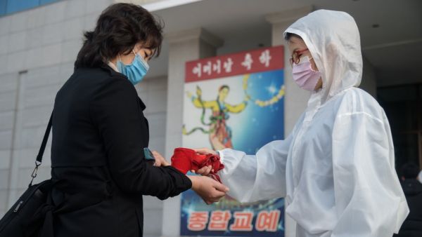 An audience member undergoes a health check as part of preventative measures against the Covid-19 coronavirus, before a performance by the North Korea's National Acrobatic Troupe at the Pyongyang Circus Theater as part of celebrations marking the annual Mother's Day public holiday, in Pyongyang on November 16, 2020. KIM Won Jin / AFP