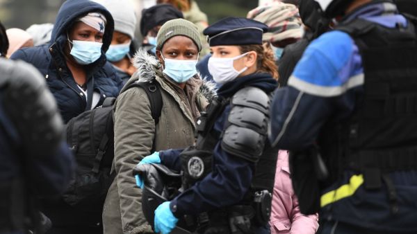 Migrants wait to be evacuated by French police at a makeshift camp set below the A1 highway in the north of Paris' popular suburb of Saint-Denis on November 17, 2020. The police will dismantle the migrant camp at the end of an evacuation operation denounced by associations as an "endless and destructive cycle". Christophe ARCHAMBAULT / AFP