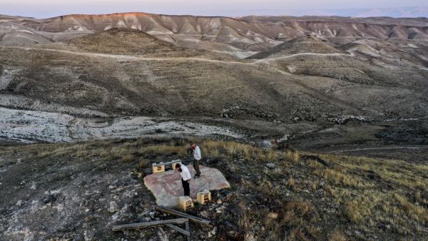 This picture taken on November 17, 2020 shows an aerial view of Orthodox Jewish men performing a noon prayer atop a hilltop near the Israeli settlement of Ma'ale Rehav'am in the occupied West Bank, south of Bethlehem. MENAHEM KAHANA / AFP