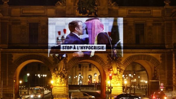 This picture taken early on November 19, 2020, shows a projection on the Louvre Museum in Paris by Amnesty International members depicting French President Emmanuel Macron greeting Saudi Crown Prince Mohammed bin Salman and reading "Stop hypocrisy", ahead of the upcoming virtual G20 summit. THOMAS COEX / AFP