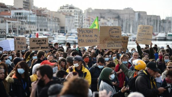 A demonstrator holds a sign reading "Macron, you won't get my freedom" during a rally on the Vieux-Port, called by the "Yellow Vests" movement (Gilets Jaunes) to protest against the "global security" draft law seeking to limit filming of police officers on duty, in Marseille, on November 21, 2020. CLEMENT MAHOUDEAU / AFP