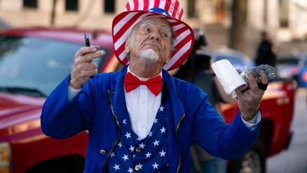 A man riding a Segway dressed as Uncle Sam taunts Biden supporters during a "Stop the Steal" rally against the results of the U.S. Presidential election outside the Georgia State Capitol on November 18, 2020 in Atlanta, Georgia. Elijah Nouvelage/Getty Images/AFP Elijah Nouvelage / GETTY IMAGES NORTH AMERICA / Getty Images via AFP