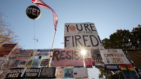 Signs critical of President Donald Trump hang on the security fence that surrounds the White House November 08, 2020 in Washington, DC. More than 75 million ballots were cast for U.S. President-elect Joe Biden and his running mate Vice President-elect Kamala Harris, who defeated Trump in his bid to be re-elected. Chip Somodevilla/Getty Images/AFP