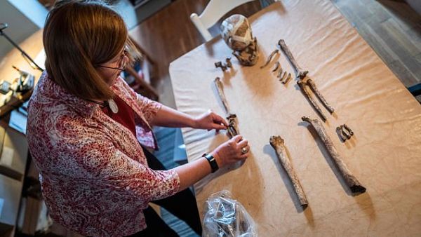 The skeleton had been buried in a settlement in a squatting position, one of the oldest known forms of burial, according to local media. Pictured, Bettina Jungklaus with the remains. (AFP)