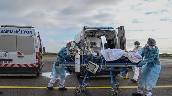 Medical staff take a patient to a waiting aircraft to be transported to another hospital in France, which is once again seeing hundreds of daily deaths linked to Covid-19 . (AFP/File)
