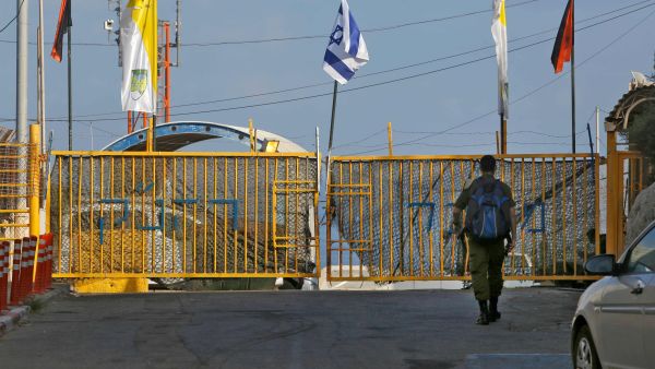 An Israeli soldier walking up to the gate of the Rosh HaNikra Crossing, also known as the Ras Al Naqoura Crossing, between Israel and Lebanon on Oct. 12, 2020. (AFP Photo)