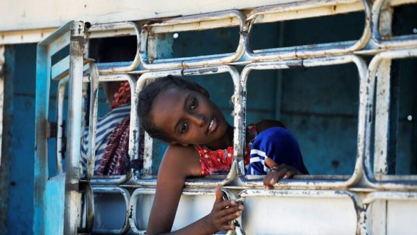 لاجئ إثيوبي ينظر من نافذة حافلة في مخيم الحمديات المؤقت للاجئين