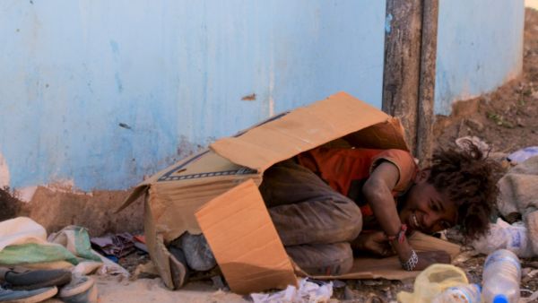 A youth of Yemen's minority group known as "Muhamasheen", which translates to marginalised, plays inside a discarded cardboard box in the capital Sanaa, on October 24, 2020. Mohammed HUWAIS / AFP