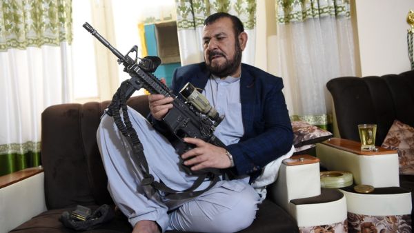 In this photo taken on September 28, 2020, former police chief of the Panjwai district, Sultan Mohammad Hakimi, poses with a gun during an interview with AFP in Panjwai. Despite the bloodshed he has witnessed throughout his career, Hakimi has made it a personal mission to give ex-Taliban fighters, commanders and officials the chance to reintegrate into village life. WAKIL KOHSAR / AFP