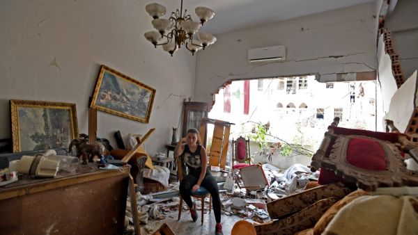 A woman sits amidst the rubble in her damaged house in the Lebanese capital Beirut on August 6, 2020. AFP