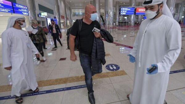 Illustrative: An Israeli man walks past Emirati staff after passport control upon arrival from Tel Aviv to the Dubai airport in the United Arab Emirates, on November 26, 2020. (Karim SAHIB / AFP)