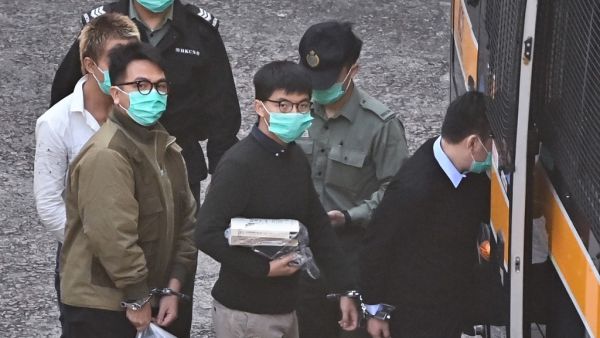 Activists Joshua Wong (C) and Ivan Lam (L) board a police van at Lai Chi Kok Reception Centre in Hong Kong on December 2, 2020, before going to court to be sentenced over a protest which took place outside the police headquarters in 2019. Anthony WALLACE / AFP