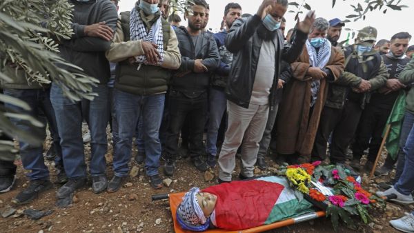 Mourners pray around the body of Palestinian teenager Ali Abu Alia during his funeral in the village of Mughayir near Ramallah in the Israeli-occupied West Bank, on December 5, 2020. The Palestinian teenager was killed in clashes with the Israeli army on the sidelines of a protest in the occupied West Bank, the Palestinian health ministry said. ABBAS MOMANI / AFP