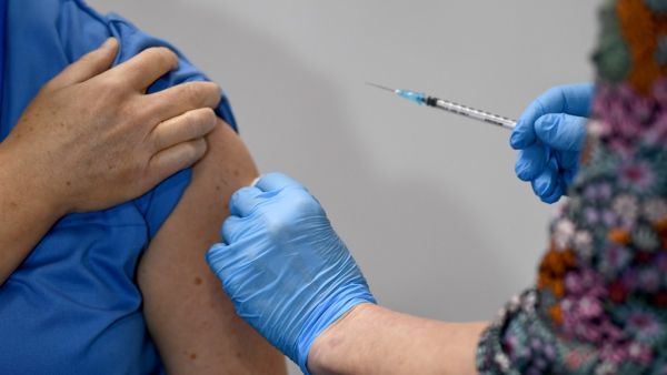 Nurse Paula McMahon (L) receives the Pfizer-BioNTech Covid-19 vaccine from nurse Karin Forrest (R) at the Louisa Jordan Hospital in Glasgow on December 8, 2020 as Britain starts is biggest ever vaccination programme. Britain on December 8 hailed a turning point in the fight against the coronavirus pandemic, as it begins the biggest vaccination programme in the country's history with a new Covid-19 jab. Jeff J Mitchell / POOL / AFP